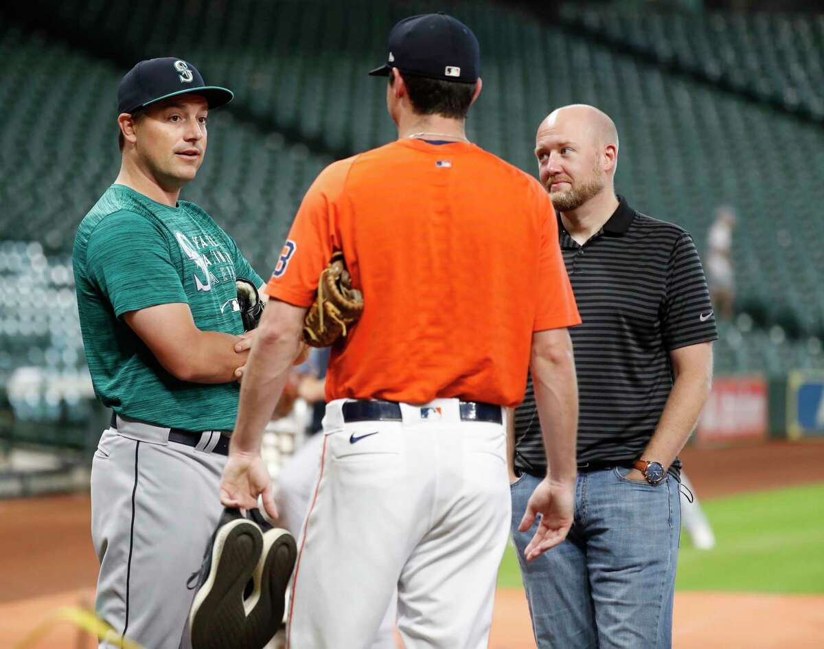 Houston Astros relief pitcher Brooks Raley talks with Seattle Mariners Joe Smith and GM James Click during batting practice before the start of an MLB baseball game at Minute Maid Park, Saturday, August 21, 2021, in Houston.