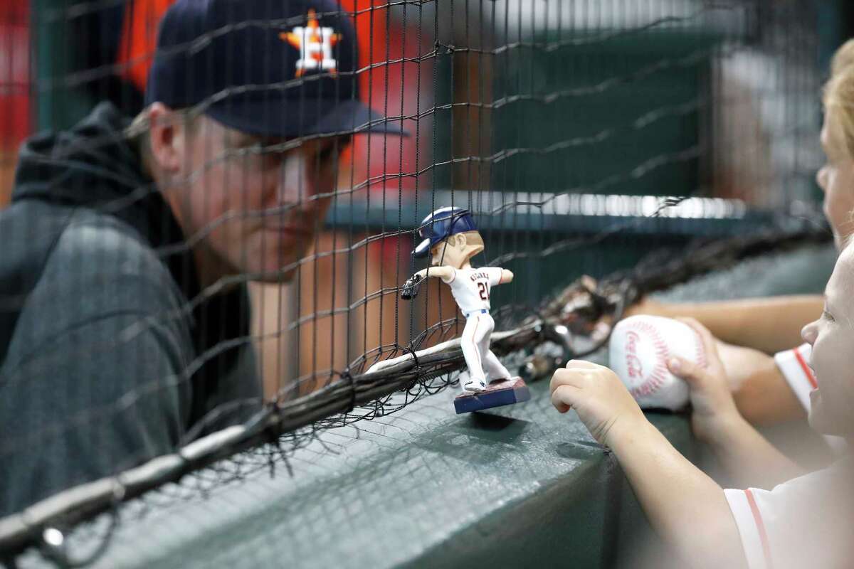 Houston Astros pitcher Zack Greinke (21) visits with his children seated in the Diamond Club with his bobblehead during the first inning of an MLB baseball game at Minute Maid Park, Saturday, August 21, 2021, in Houston.
