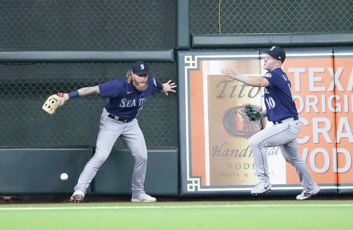 Seattle Mariners left fielder Jake Fraley (28) and center fielder Jarred Kelenic (10) chase Houston Astros Jacob Wilson's triple during the third inning of an MLB baseball game at Minute Maid Park, Saturday, August 21, 2021, in Houston.