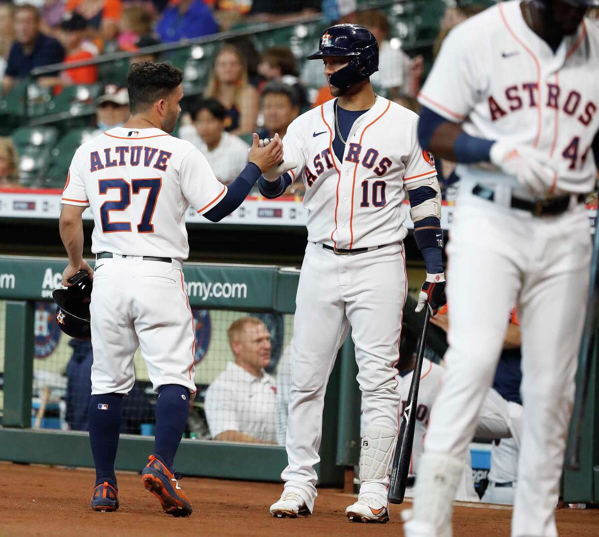 Houston Astros second baseman Jose Altuve (27) celebrates his run scored with Yuli Gurriel (10) on Carlos Correa's ground out during the first inning of an MLB baseball game at Minute Maid Park, Saturday, August 21, 2021, in Houston.