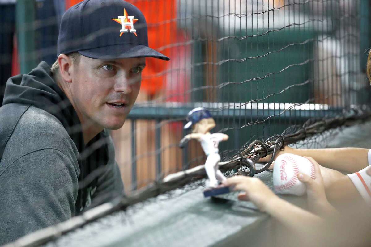 Houston Astros pitcher Zack Greinke (21) visits with his children seated in the Diamond Club with his bobblehead during the first inning of an MLB baseball game at Minute Maid Park, Saturday, August 21, 2021, in Houston.