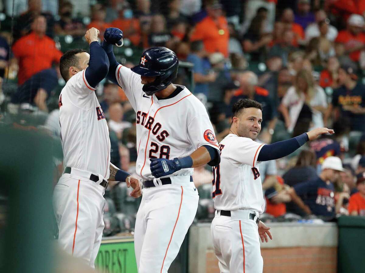 Houston Astros Taylor Jones (28) celebrates his home run off of Seattle Mariners starting pitcher Logan Gilbert with Carlos Correa (1) and Jose Altuve (27) during the fourth inning of an MLB baseball game at Minute Maid Park, Saturday, August 21, 2021, in Houston.