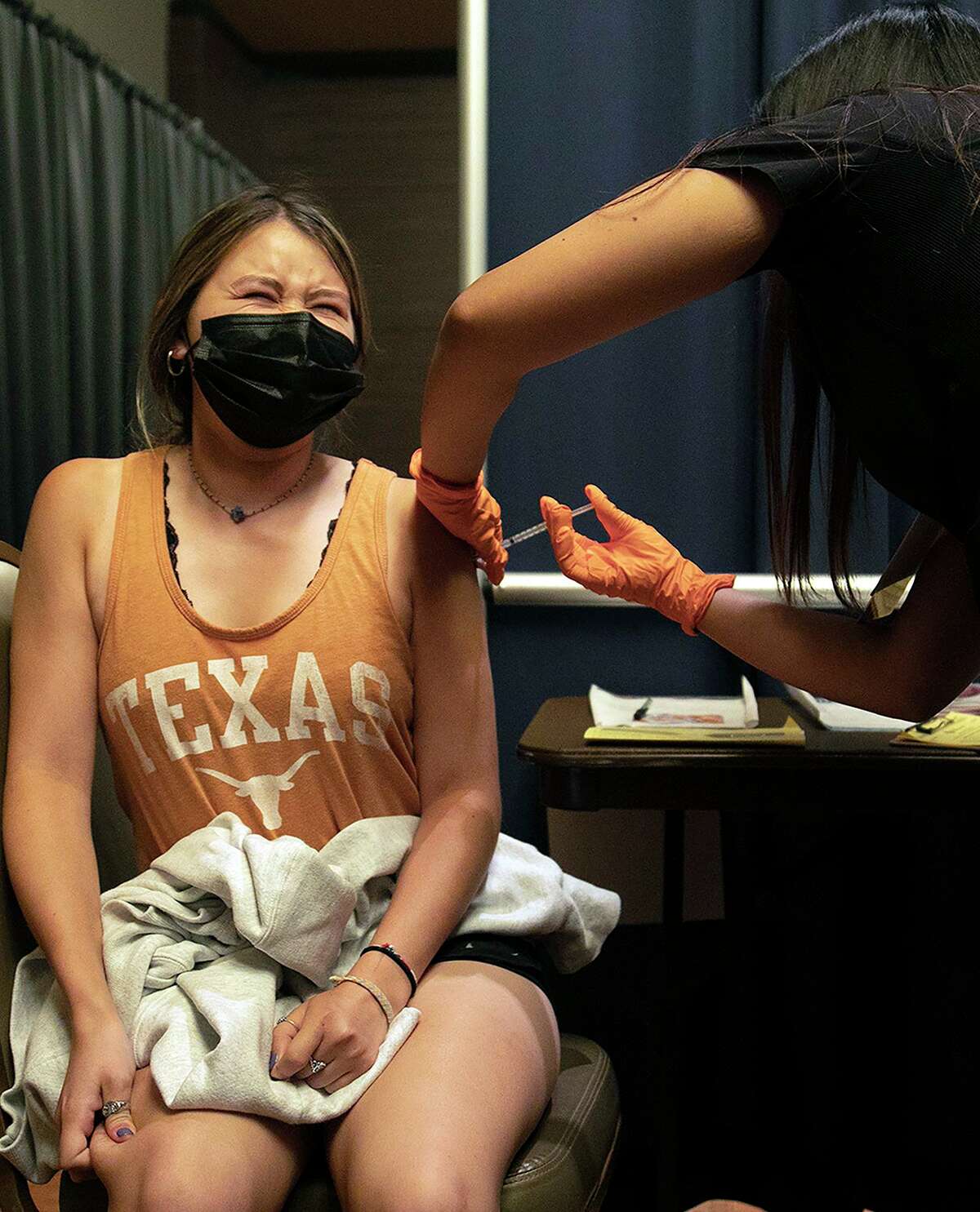 Student Emily Schelstrate winces as Metro Health nurse Lizet Nelms, right, administers the Moderna vaccine during a pop-up vaccination clinic at the University of Texas at San Antonio on July 14.