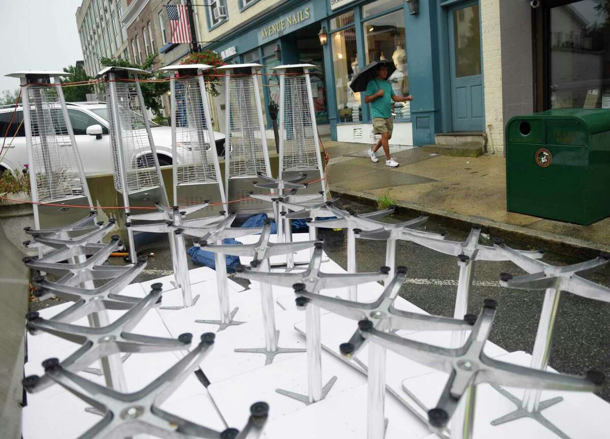 Outdoor furniture is put away as a precaution outside Abis Japanese Restaurant as Tropical Storm Henri hits Greenwich, Conn. Sunday, Aug. 22, 2021. Henri was downgraded from a hurricane to a tropical storm as the storm took a turn eastward before hitting land.