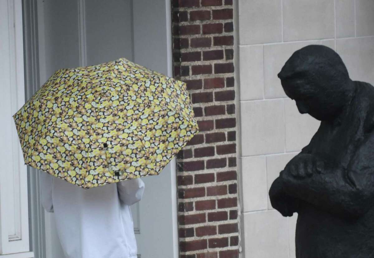 Folks take cover from the rain as Tropical Storm Henri hits Greenwich, Conn. Sunday, Aug. 22, 2021. Henri was downgraded from a hurricane to a tropical storm as the storm took a turn eastward before hitting land.