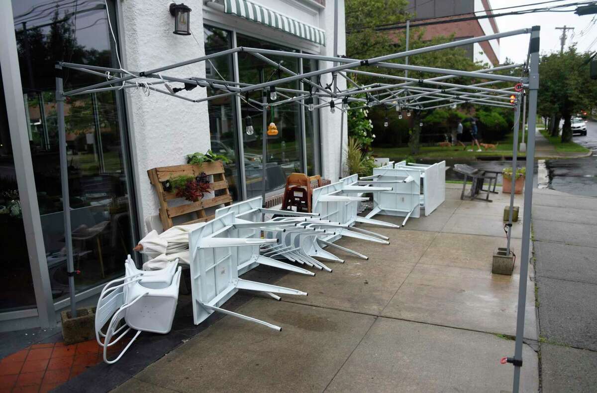 Outdoor furniture is put away as a precaution as Tropical Storm Henri hits Greenwich, Conn. Sunday, Aug. 22, 2021. Henri was downgraded from a hurricane to a tropical storm as the storm took a turn eastward before hitting land.