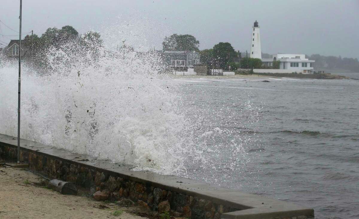 Waves crash against the sea wall near New London Harbor Lighthouse as Tropical Storm Henri approaches Sunday, Aug. 22, 2021, in New London, Conn.
