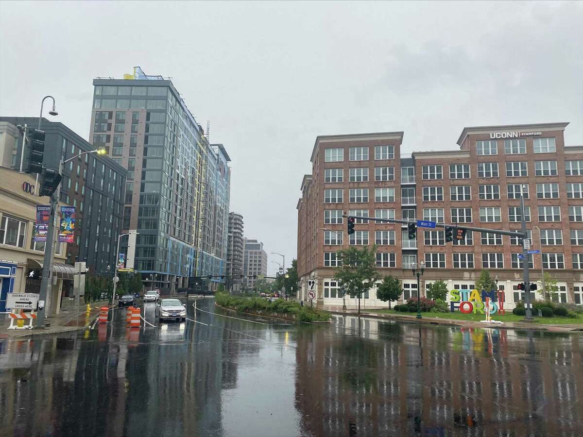 A car slowly drives in downtown Stamford the rain as Tropical Storm Henri hits on Sunday, Aug. 22, 2021. Henri was downgraded from a hurricane to a tropical storm as the storm took a turn eastward before hitting land.