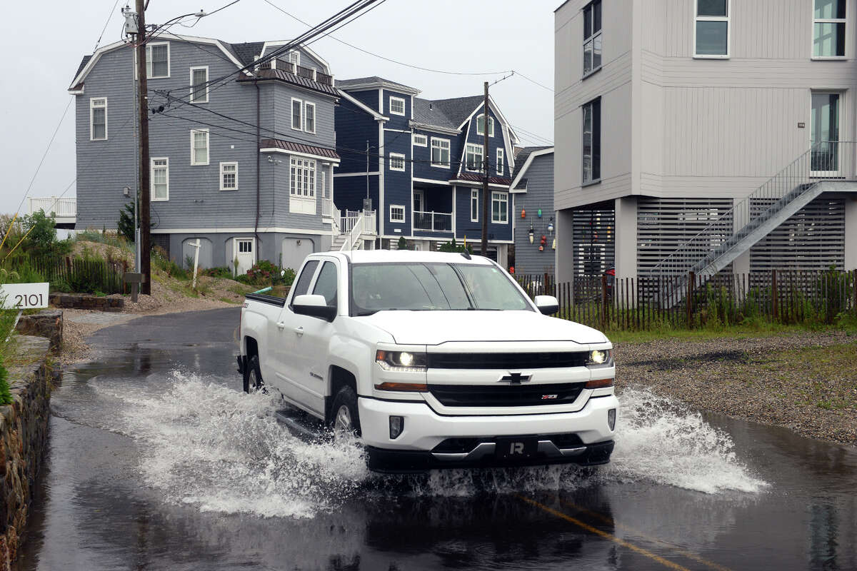 High tide brought the waters of Long Island Sound onto a short stretch of Fairfield Beach Rd., in Fairfield, Conn. Aug. 22, 2021. As Tropical Storm Henri passed farther to the east, most of coastal Fairfield County experienced an ordinary rainy day on Sunday.