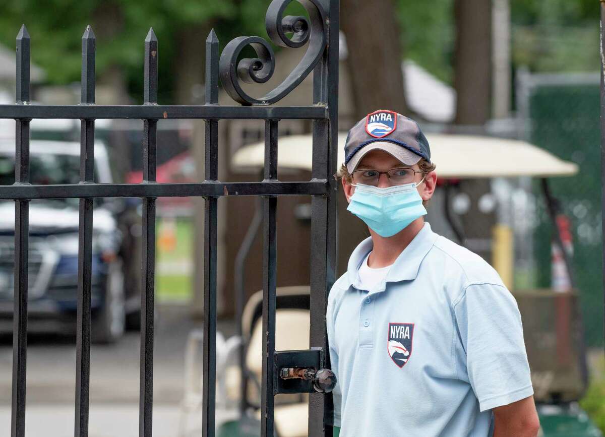 NYRA Security member Liam Dreyer wears a face mask as he works the entry gate near the Whitney entrance at the Saratoga Race Course on Sunday Aug 22, 2021.