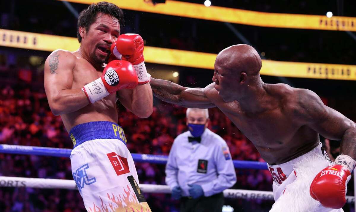 Manny Pacquiao takes a punch from Yordenis Ugas during their WBA welterweight title fight in Las Vegas on Saturday. Ugas retained his title by unanimous decision.