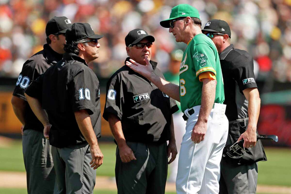 Oakland Athletics' manager Bob Melvin talks with umpires after they ruled Mark Canha was hit by batted ball on base paths in 6th inning against San Francisco Giants during MLB game at Oakland Coliseum in Oakland, Calif., on Sunday, August 22, 2021.
