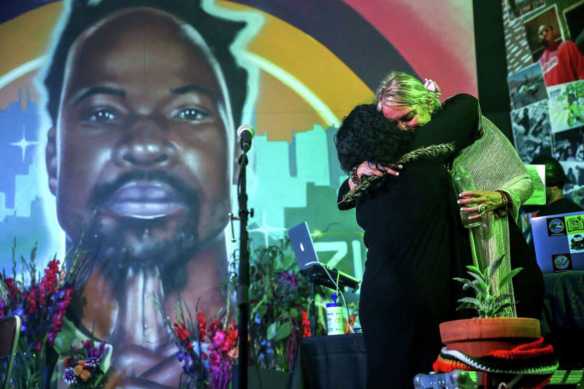 Millaray Rodriguez Avila (right), partner of Stephen “Zumbi” Gaines, embraces Jo “love/speak” Cruz during a tribute to the hip-hop artist in Oakland. Gaines died this month at Alta Bates Summit Medical Center in Berkeley.