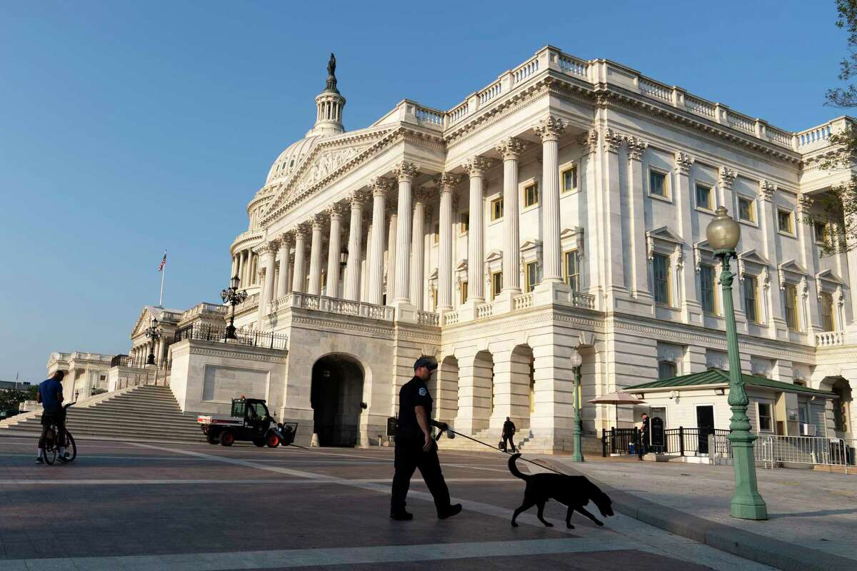 The U.S. Capitol is seen in Washington, early Tuesday, July 27, 2021, as U.S. Capitol Police watch the perimeter. Democrats are launching their investigation into the Jan. 6 Capitol insurrection. They're beginning with a focus on the law enforcement officers who were attacked and beaten as the rioters broke into the building. It's an effort to put a human face on the violence of the day. The police officers who are testifying Tuesday endured some of the worst of the brutality. The panel's first hearing comes as partisan tensions have only worsened since the insurrection. Many Republicans have played down or outright denied the violence that occurred and denounced the Democratic-led investigation as politically motivated.