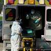 Ambulance workers sanitize after dropping off a patient for antibody treatment.