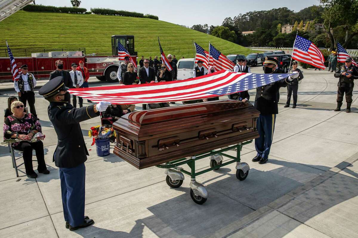 Members of the Honor Guard prepare to fold the flag during a funeral honoring the life of Oakland native and World War II pilot Lt. Earl “Buddy” Smith at Golden Gate National Cemetery in San Bruno, Calif.