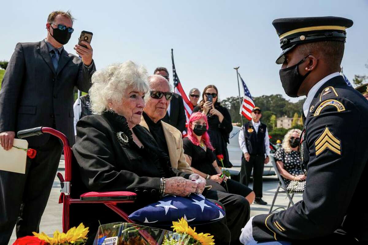 Bonnie Fitch, niece to Oakland native and World War II pilot Lt. Earl “Buddy” Smith, receives a medal from a U.S. sergeant with the Honor Guard during a funeral for Smith at Golden Gate National Cemetery in San Bruno, Calif. on Monday, Aug. 23, 2021. Smith was 22 years old when his fighter jet crashed into the ocean near Papua New Guinea in 1943. His body was deemed non-recoverable after several investigations. In 2002, his remains were discovered by recreational divers. Smith’s family. Has since worked with the Defense POW/MIA Accounting Agency to recover his remains and give Smith a proper burial on American soil.