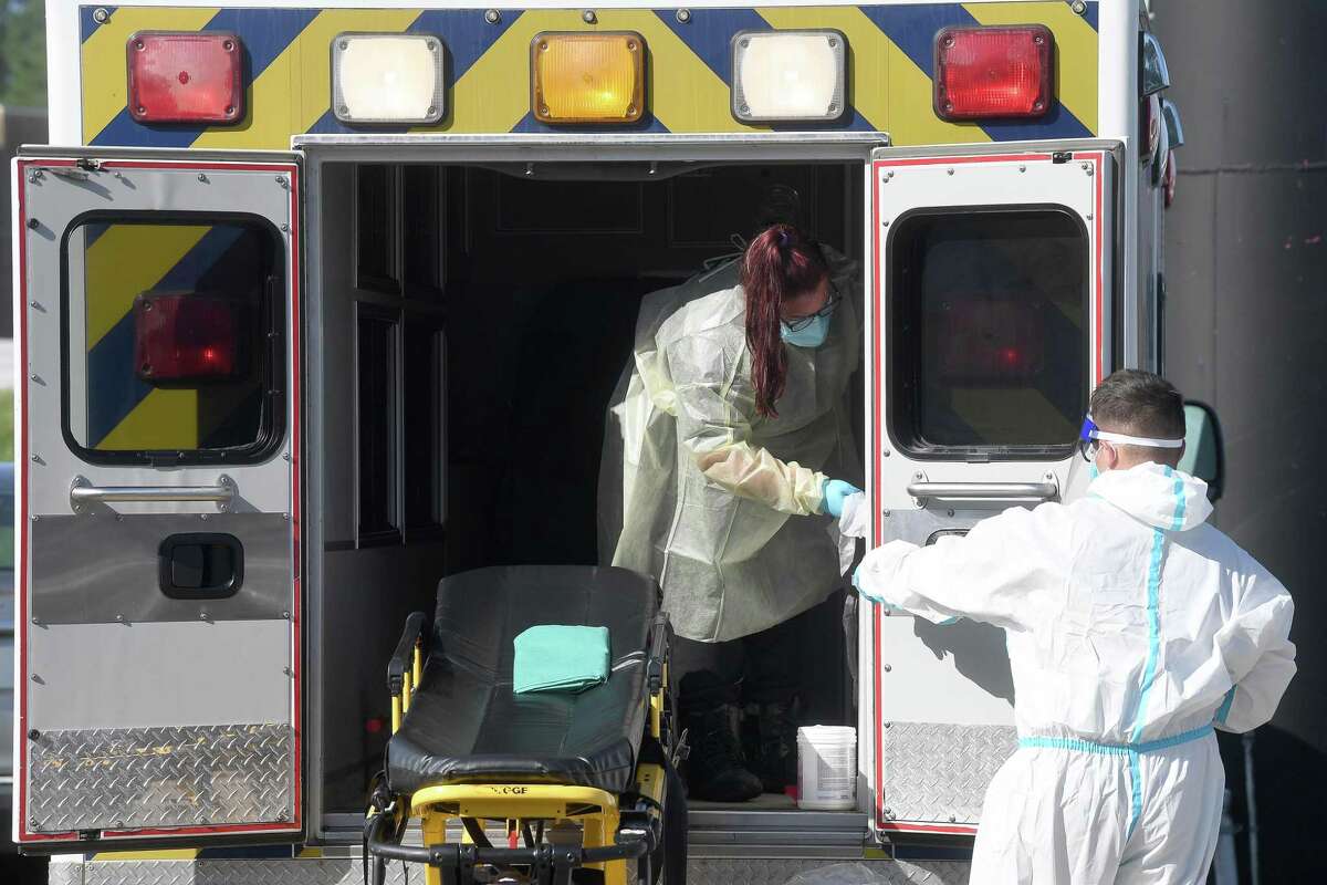 Ambulance workers sanitize their unit and gurney after transporting a patient to the new monoclonal antibody infusion center that opened Monday to help treat patients with COVID-19. The new center will be able to treat up to 150 patients daily, significantly increasing the number that can be treated amid a steep rise in cases. The treatment is free to patients 12 and older who are within 10 days of conntracting the virus and are not experiencing severe respiratory problems, Photo made Monday, August 23, 2021 Kim Brent/The Enterprise