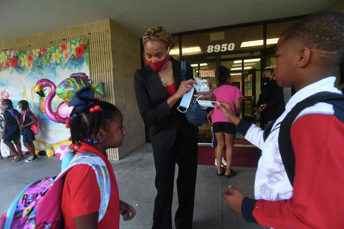 Principal Belinnda Georrge gives masks to students who said they didn't have any on the first day of school at Homer Drive Elementary. Photo made Tuesday, August 17, 2021 Kim Brent/The Enterprise