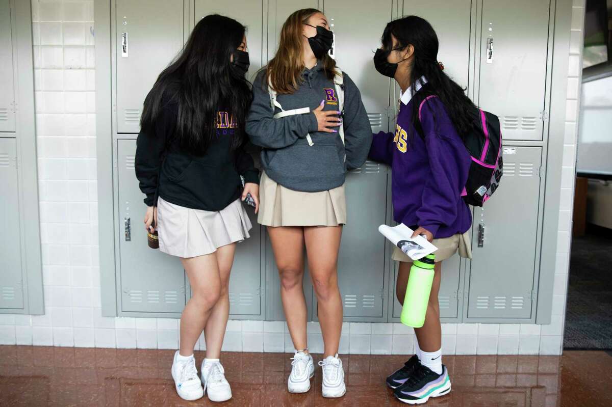 A group of girls socialize in the halls before class during the first day of coed in-person learning at Archbishop Riordan High School in San Francisco on Thursday.