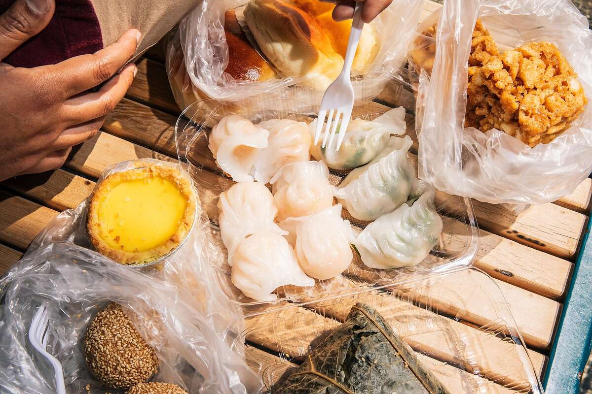 Clockwise from top left: Baked barbecue pork bun, sachima sticky rice in a lotus leaf, sesame dumplings, egg tart, cooked har gow and chive dumplings steamer from Good Mong Kok Bakery pictured in Chinatown in San Francisco, California on Saturday August 14, 2021.