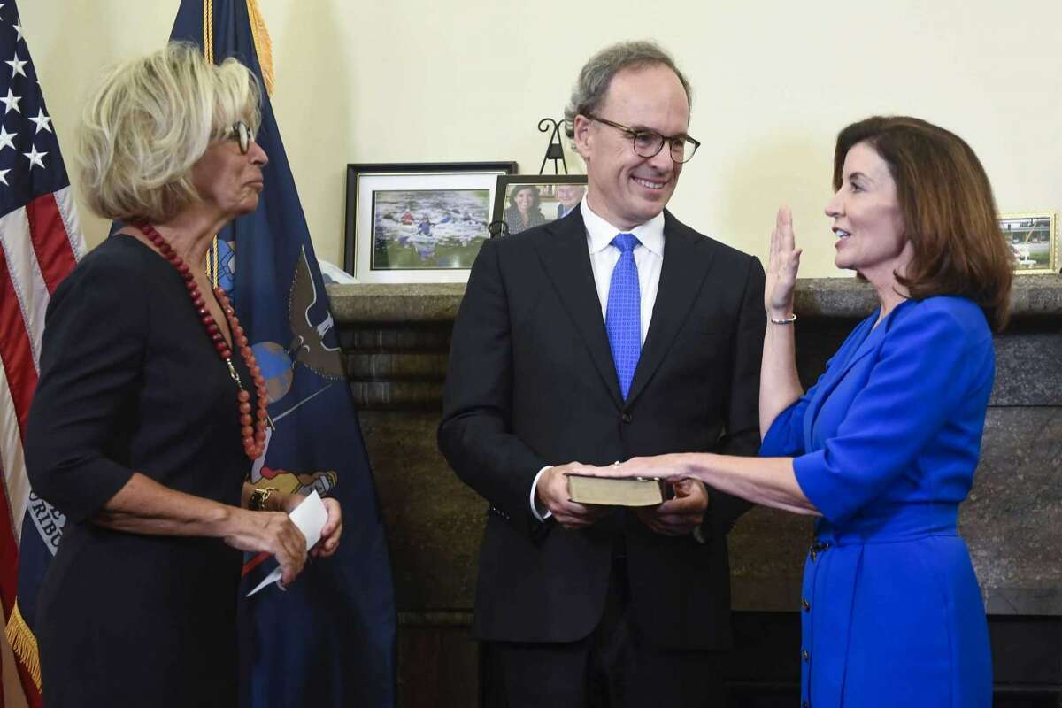 New York Chief Judge Janet DiFiore, left, swears in Kathy Hochul, right, as the first woman to be New York's governor while her husband Bill Hochul holds a bible during a swearing-in ceremony in the Red Room at the state Capitol, early Tuesday, Aug. 24, 2021, in Albany, N.Y.