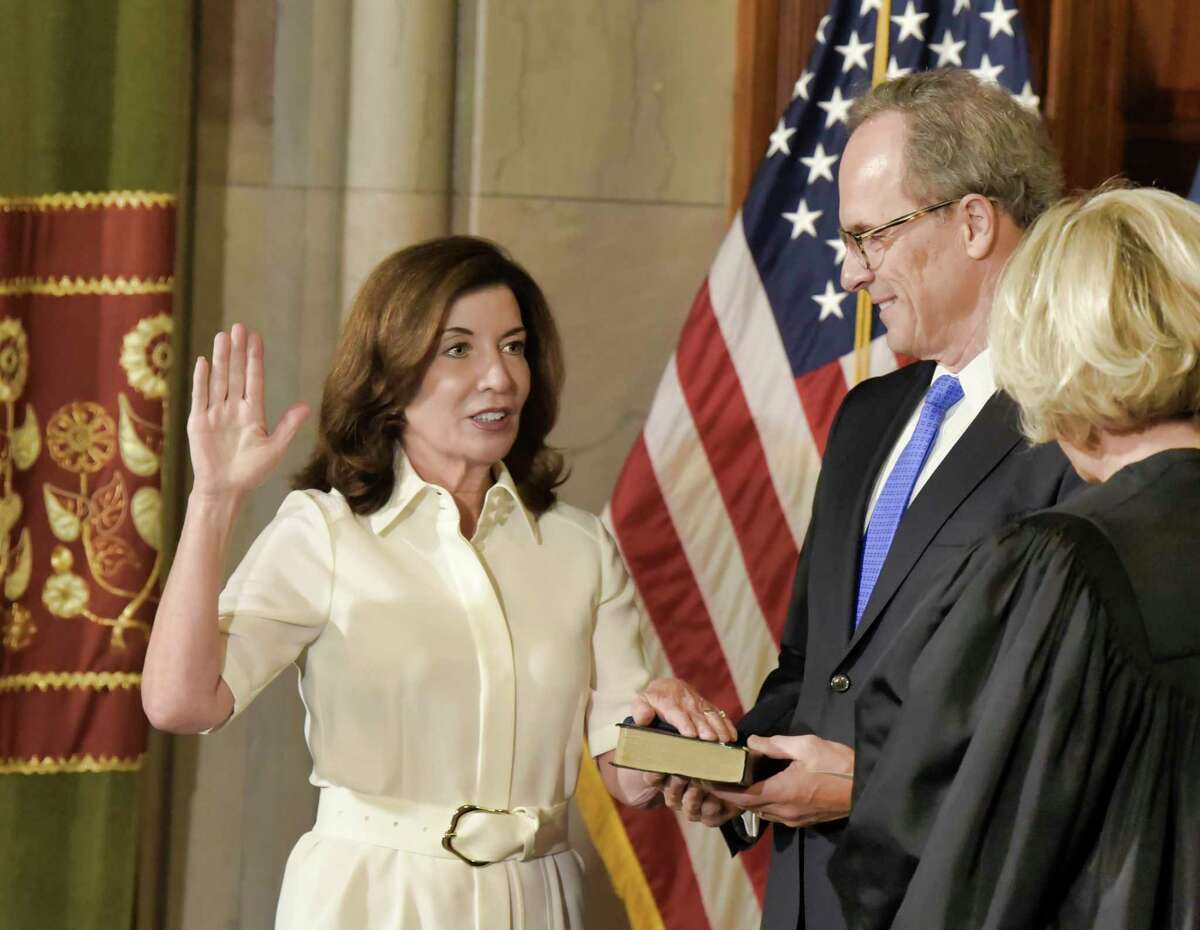 New York Chief Judge Janet DiFiore, right, swears in Kathy Hochul as the first woman to be governor of New York, while her husband Bill Hochul holds a bible during a ceremonial swearing-in ceremony at the Capitol, Tuesday, Aug. 24, 2021, in Albany, N.Y.