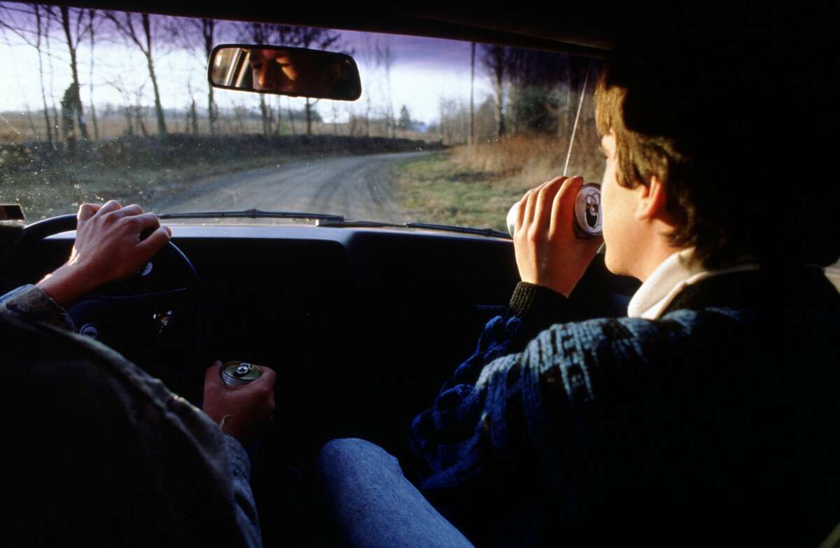 Pictured is two teenagers drinking and driving.