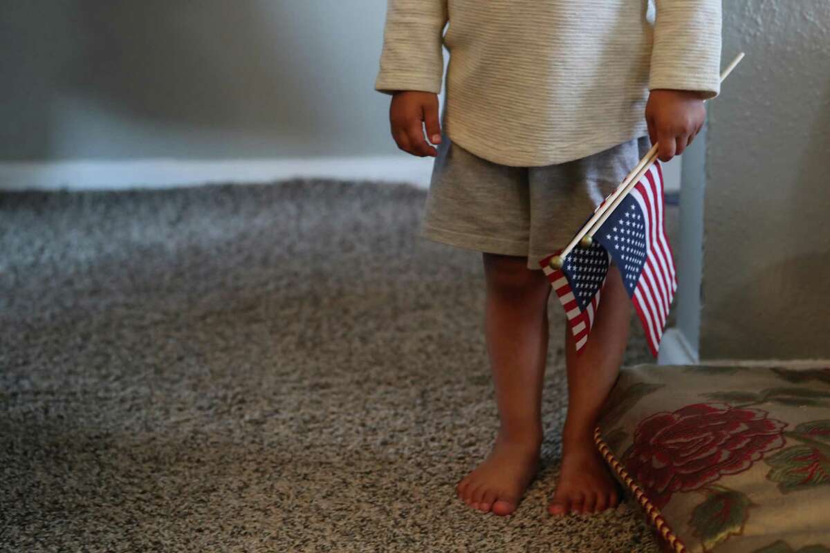 The 3-year old son of “Khan”, an Afghan ally, holds a pair of American flags after fleeing the Taliban in Afghanistan on Monday, Aug. 23, 2021 in Houston. The family arrived in Houston Sunday night.