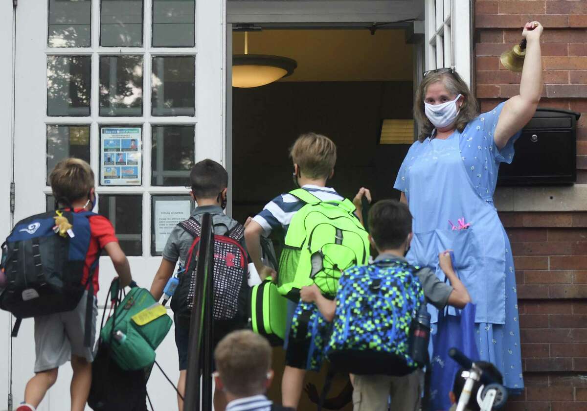 Old Greenwich School Principal Jennifer Bencivengo rings the bell on the first day of the 2020-2021 school year at Old Greenwich School in Old Greenwich, Conn. Wednesday, Sept. 9, 2020.