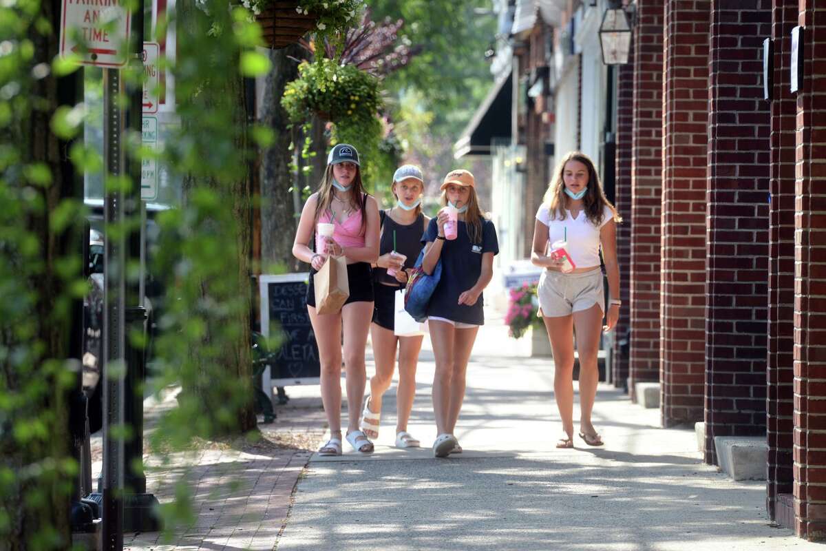 A group of girls walk along a sidewalk on the Post Rd., in Fairfield, Conn. Aug. 24, 2021.