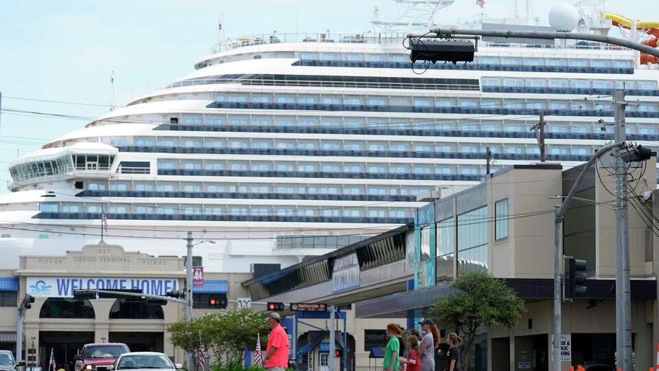 The Carnival Vista is shown at the Port of Galveston as traffic and people move along 25th St. Friday, July 2, 2021 in Galveston. The Carnival Vista will be the first cruise to sail out of Galveston since the pandemic.