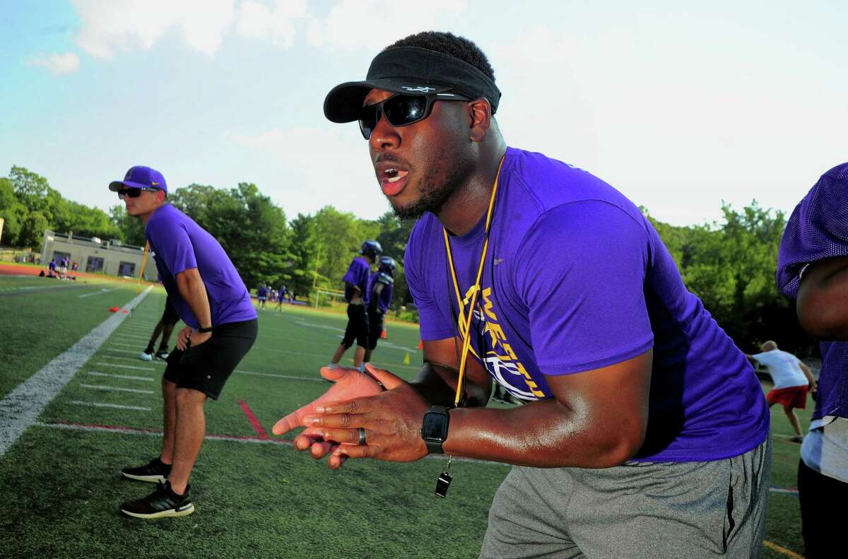 Westhill High School football coach Aland Joseph drills his players during practice at the school in Stamford, Conn., on Tuesday August 24, 2021.