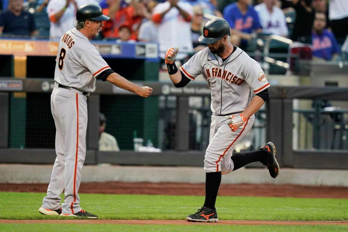 San Francisco Giants' Brandon Belt, right, celebrates with third base coach Ron Wotus as he runs the bases after hitting a home run during the first inning of the team's baseball game against the New York Mets on Tuesday, Aug. 24, 2021, in New York. (AP Photo/Frank Franklin II)