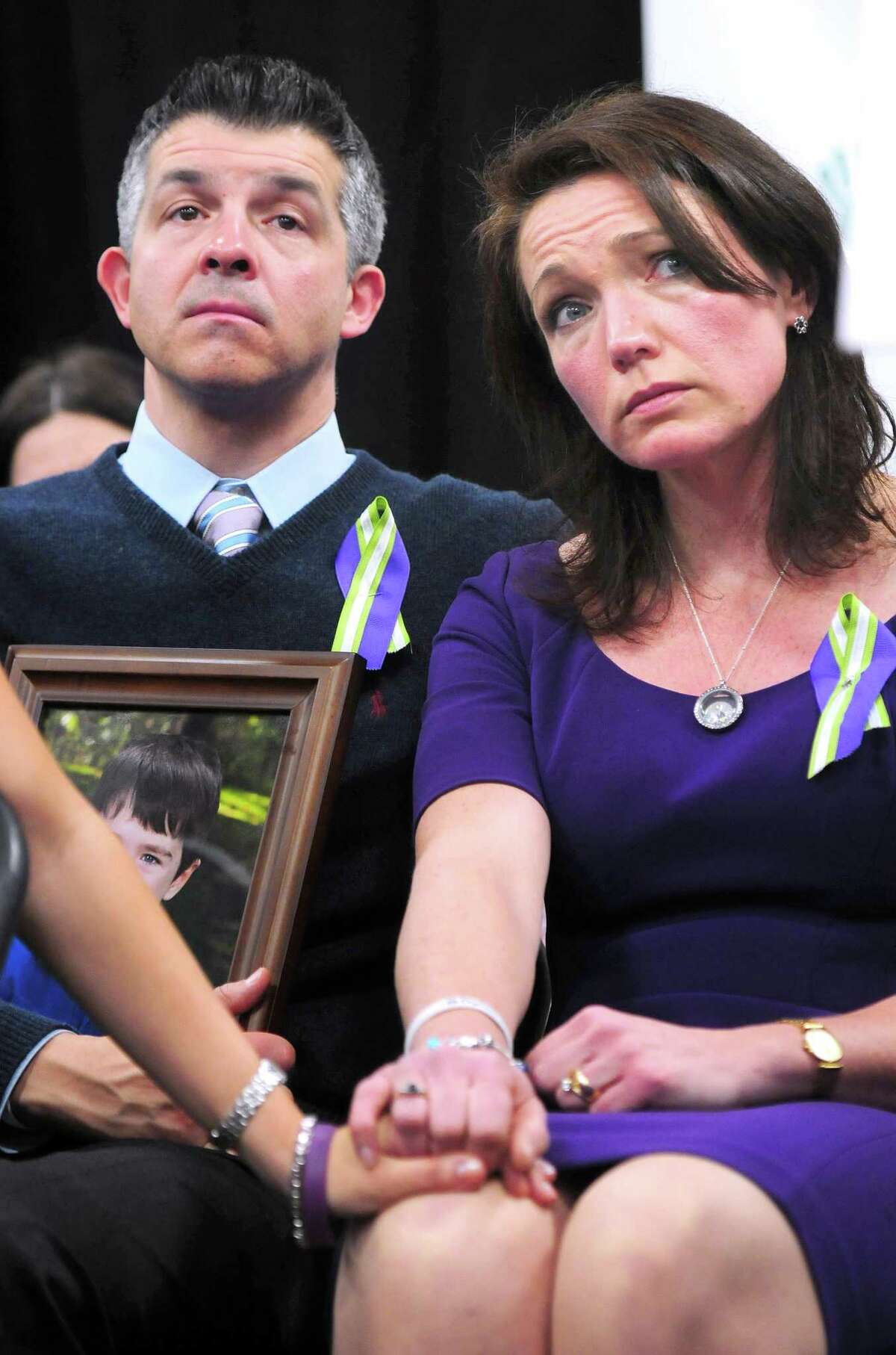 Ian Hockley (left) holding a photograph of his son, Dylan, and his wife, Nicole (right), listen to speakers a press conference announcing the launch of Sandy Hook Promise at Edmond Town Hall in Newtown on 1/14/2013. Dylan was killed in the Sandy Hook Elementary School shootings. Photo by Arnold Gold/New Haven Register