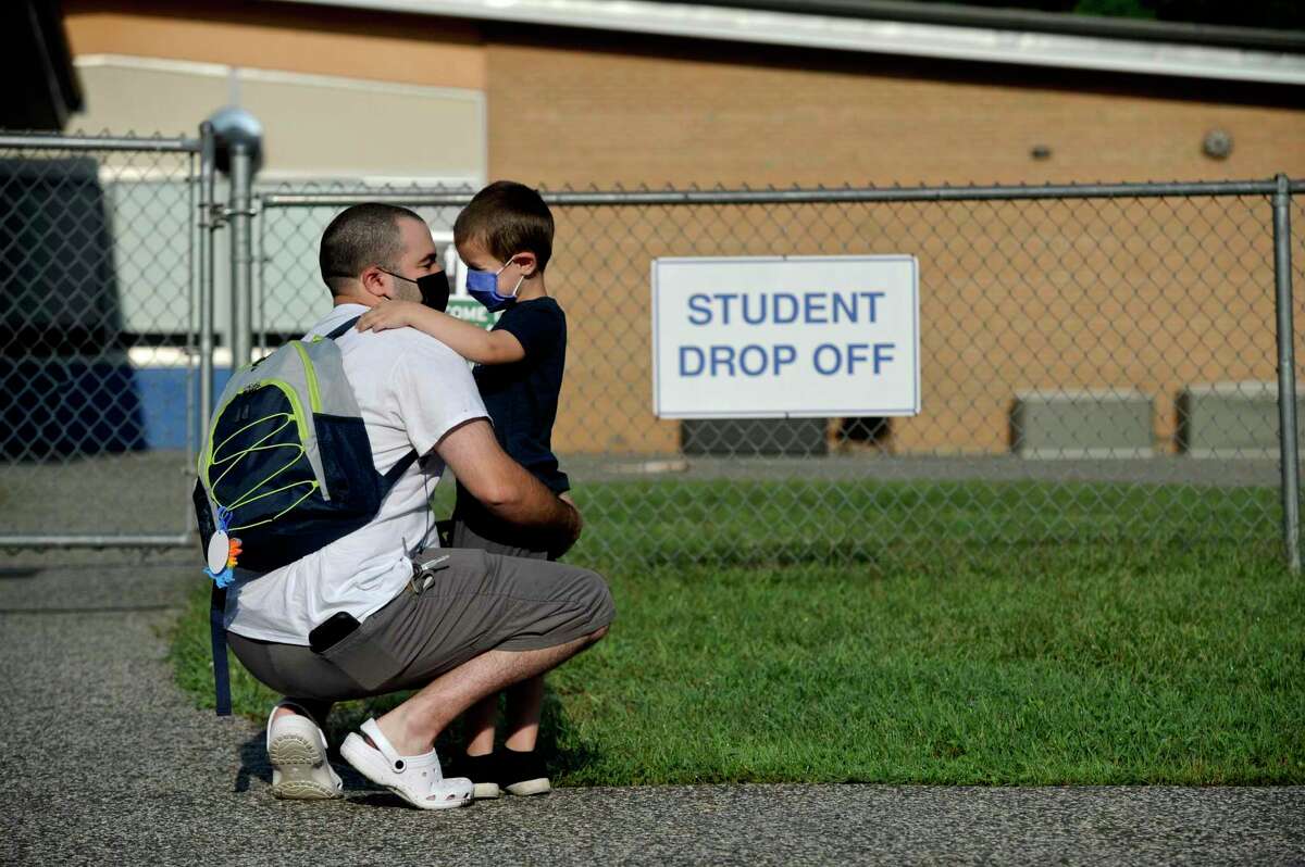 Willam Lopes, 5, waits with his father Elliott Lopes for the start of his first day of kindergarten. It was the first day of the new school year at Hill and Plain Elementary School, New Milford, Conn. Wednesday, August 25, 2021.