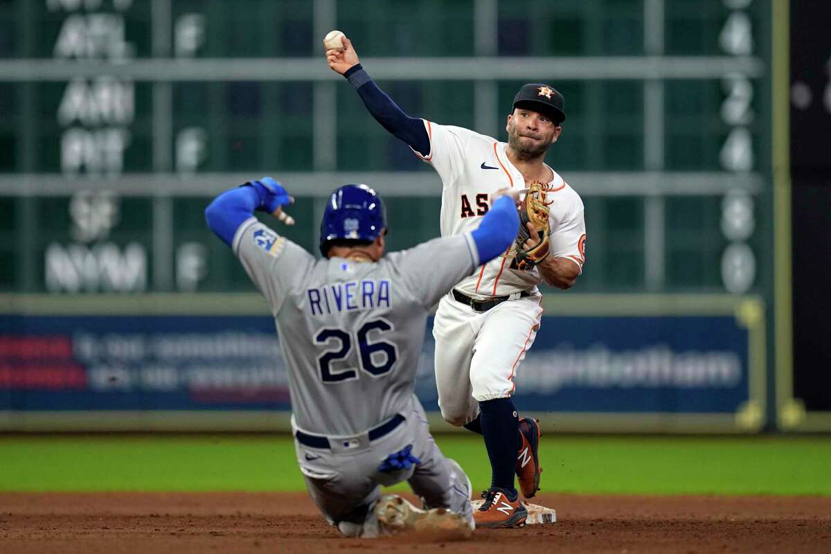 Houston Astros second baseman Jose Altuve, right, throws to first for a double play as Kansas City Royals' Emmanuel Rivera (26) slides into second base during the eighth inning of a baseball game Tuesday, Aug. 24, 2021, in Houston.