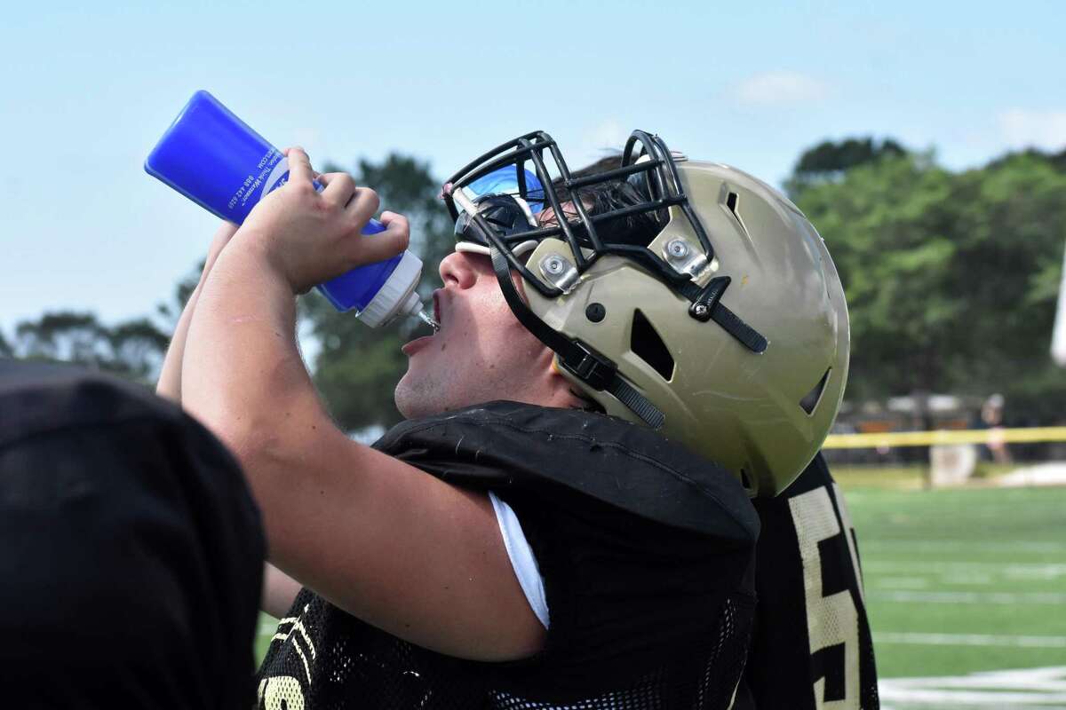 Hand players take a drink of water in between reps during a joint practice against Greenwich at Strong Field, Madison on Tuesday, August 24, 2021.
