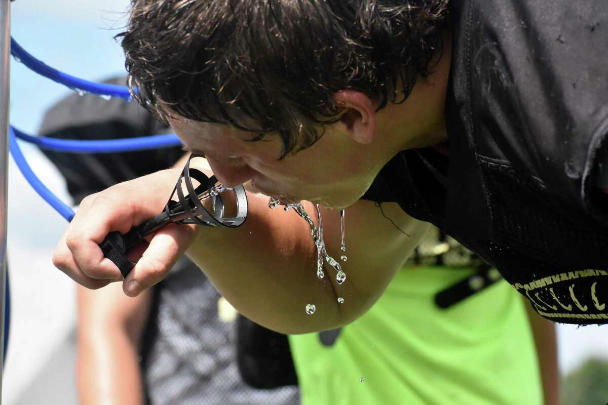 Hand's Seth Sweitzer drinks water in between reps during a joint practice against Greenwich at Strong Field, Madison on Tuesday, August 24, 2021.