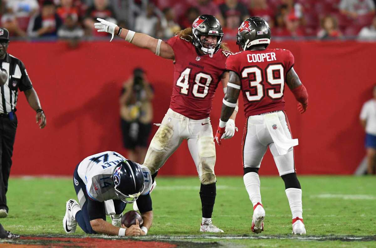 Tampa Bay Buccaneers linebacker Grant Stuard (48) celebrates with defensive back Chris Cooper (39) after sacking Tennessee Titans quarterback Matt Barkley (14) during the second half of an NFL preseason football game Saturday, Aug. 21, 2021, in Tampa, Fla. (AP Photo/Jason Behnken)