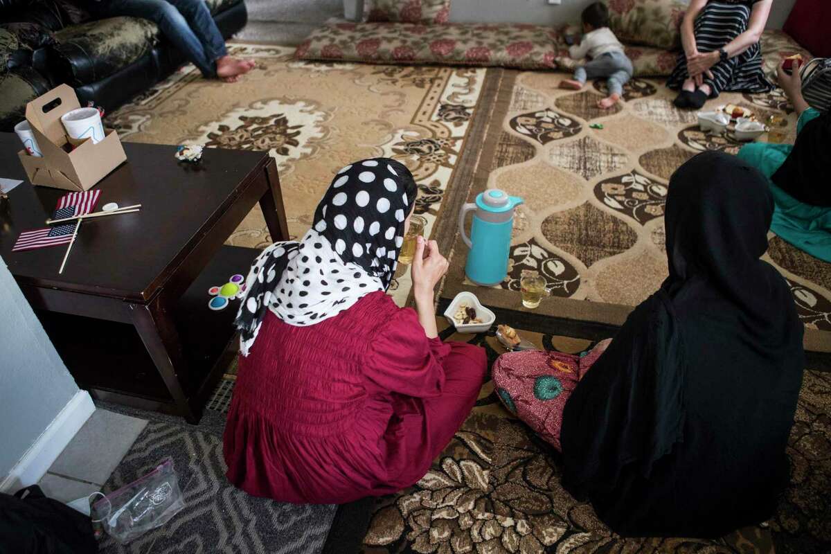 Family members of “Khan,” an Afghan Special Immigrant Visa holder, have tea as they settle into an apartment after fleeing the Taliban in Afghanistan on Monday, Aug. 23, 2021 in Houston. Some other arriving Afghans will not be Special Immigrant Visa holders, officials said.