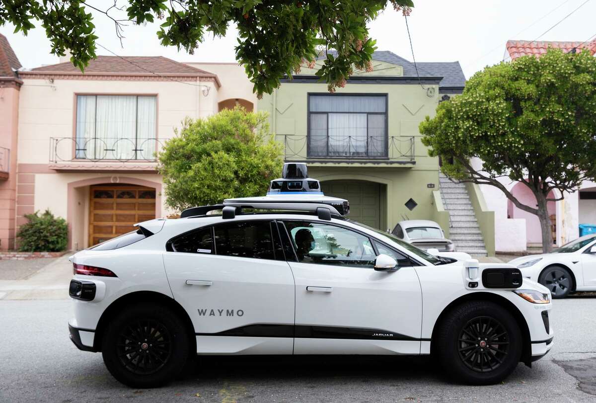A Waymo robot taxi arrives to pick up passengers during a demonstration ride in the Sunset District.