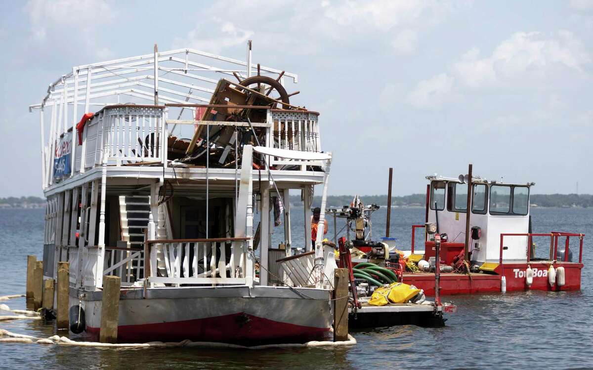 The Lake Conroe Queen is seen being hitched to the back of a tow boat by Lewis Towing & Salvage, Friday, Aug. 20, 2021, in Lake Conroe. The Lake Conroe Queen capsized Saturday near Regency Point during a thunderstorm.