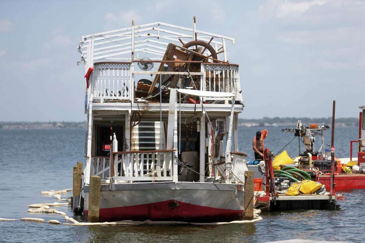 The Lake Conroe Queen is seen being hitched to the back of a tow boat by Lewis Towing & Salvage, Friday, Aug. 20, 2021, in Lake Conroe. The Lake Conroe Queen capsized Saturday near Regency Point during a thunderstorm.