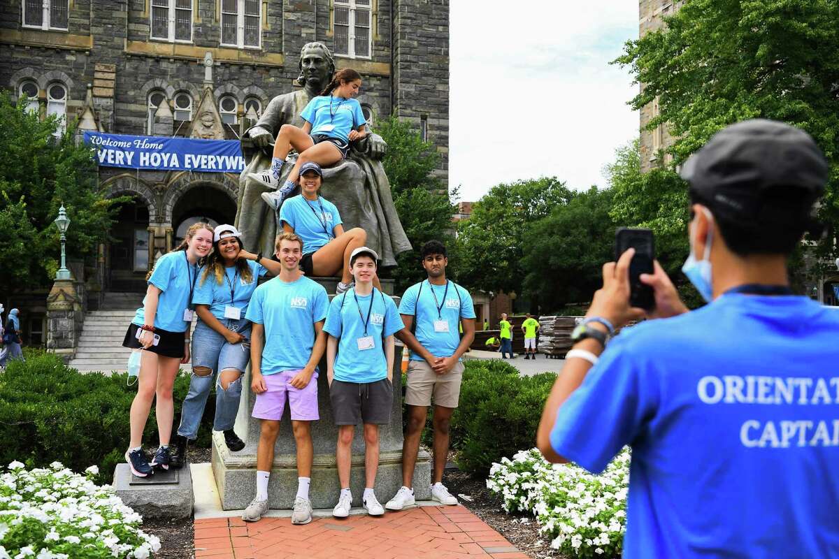 Orientation captains at Georgetown University stand together for a photo in front of a statue of school founder John Carroll on Aug. 20.