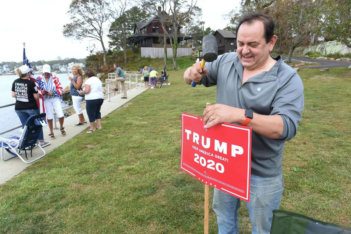 Dominic Rapini of Branford plants a Trump sign at the Boaters for Trump and Blue Lives Matters Boat Parade at Branford Point on September 26, 2020.