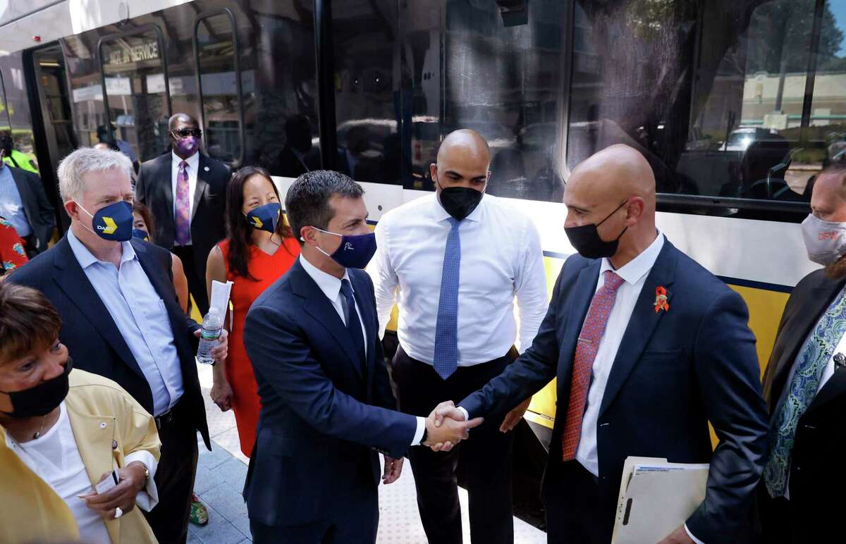 U.S. Transportation Secretary Pete Buttigieg, center, shakes hands with Texas Department of Transportation Dallas District Engineer Mo Bur as they depart a Dallas Area Rapid Transit train at the Lovers Lane station in Dallas on Aug. 11, 2021. Buttigieg toured some of Dallas' transportation sites to see and hear how the Bipartisan Infrastructure Deal’s investments in jobs, airports and transit will benefit the area.