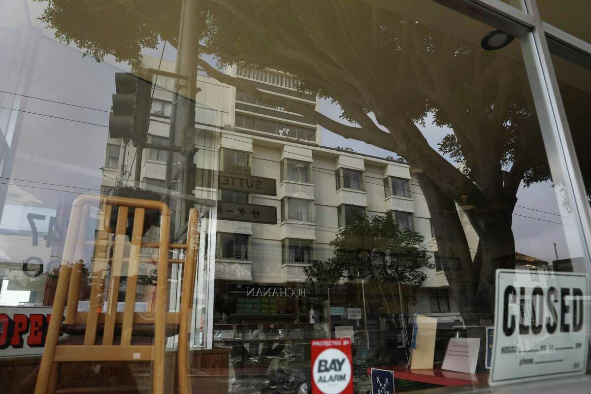 The Kimpton Buchanan Hotel is reflected in the window of Benkyodo across the street.