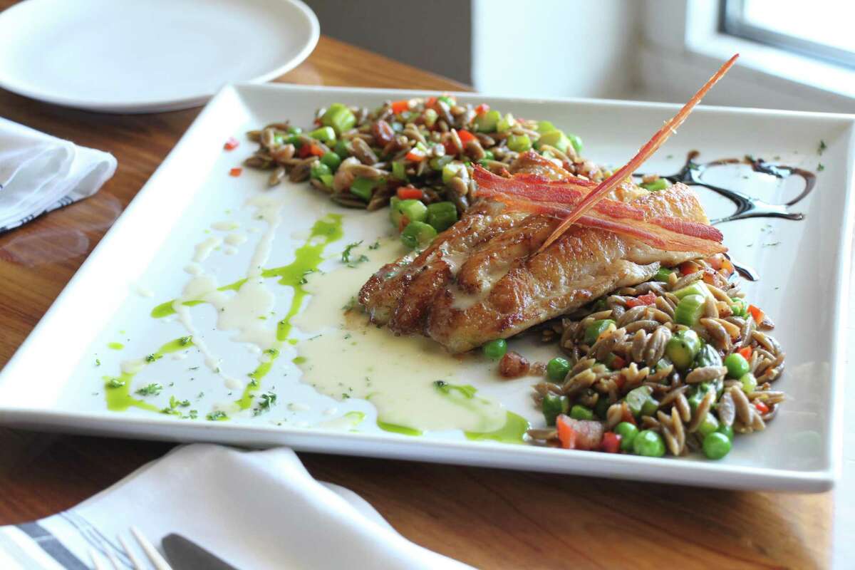 Pan-seared New Zealand butterfish with porcini orzo, English peas, crispy pancetta, and preserved lemon beurre blanc at the West Table restaurant in Lubbock, Texas.