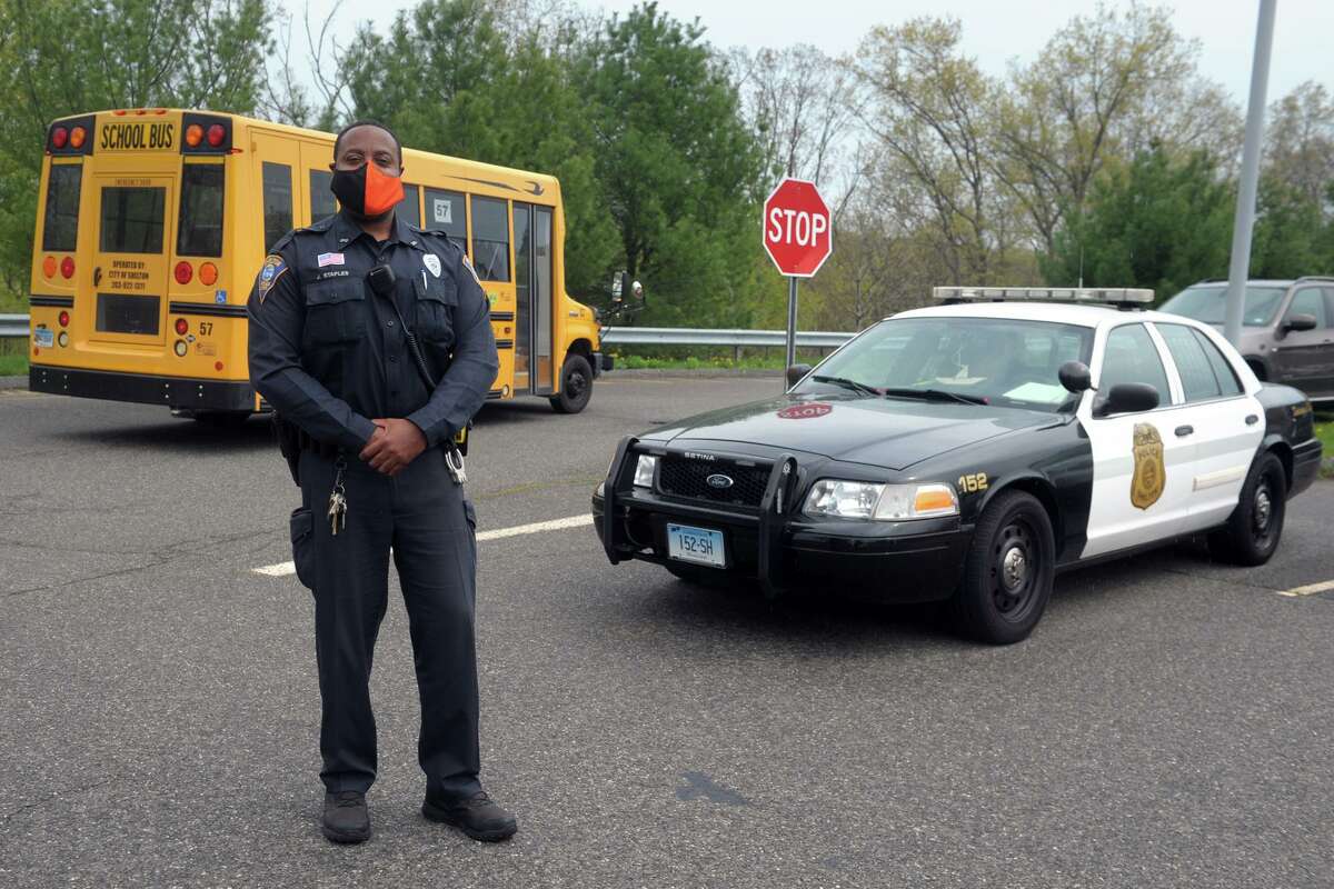 Shelton Police Officer John Staples poses in front of Perry Hill School, in Shelton, Conn. April 29, 2021.